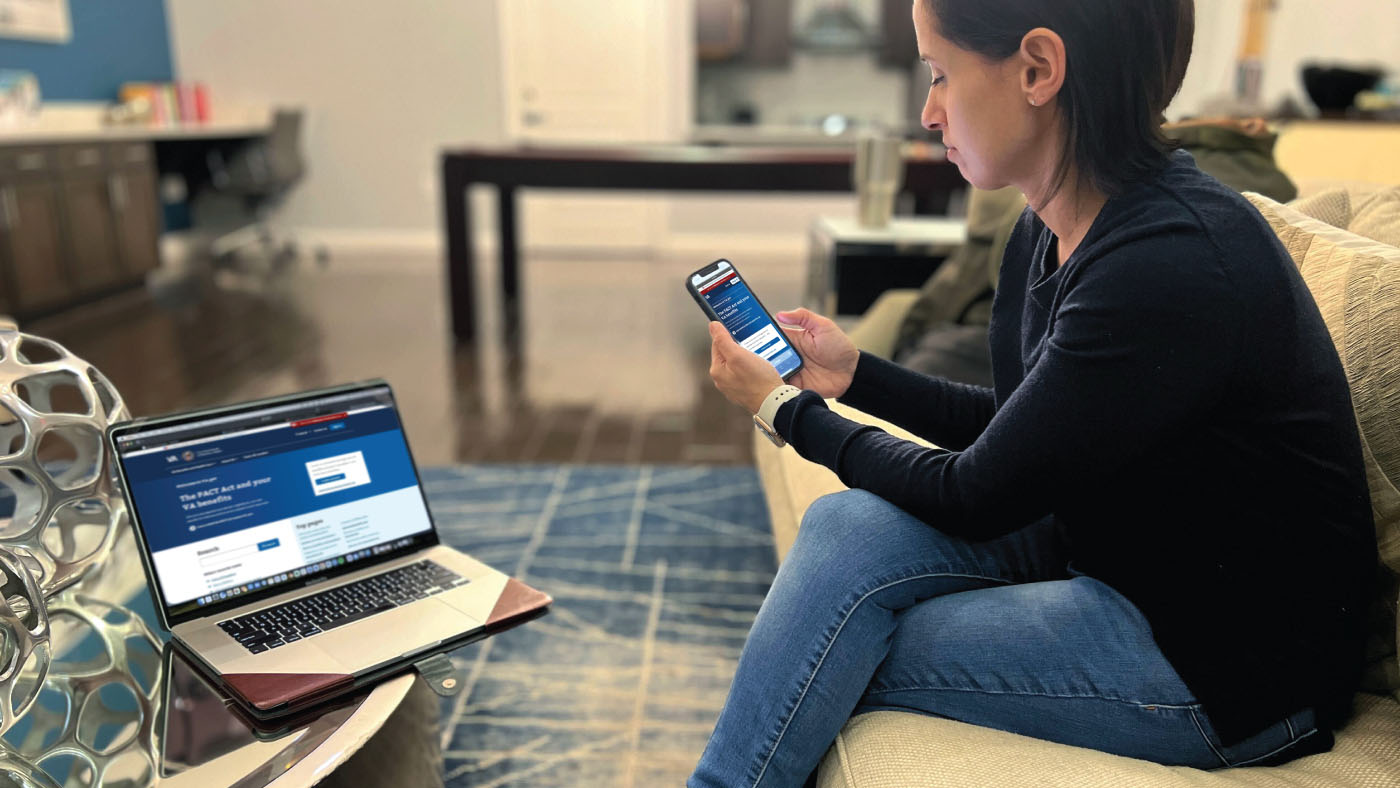 Woman using a mobile phone and laptop to sign into securely to the VA network.