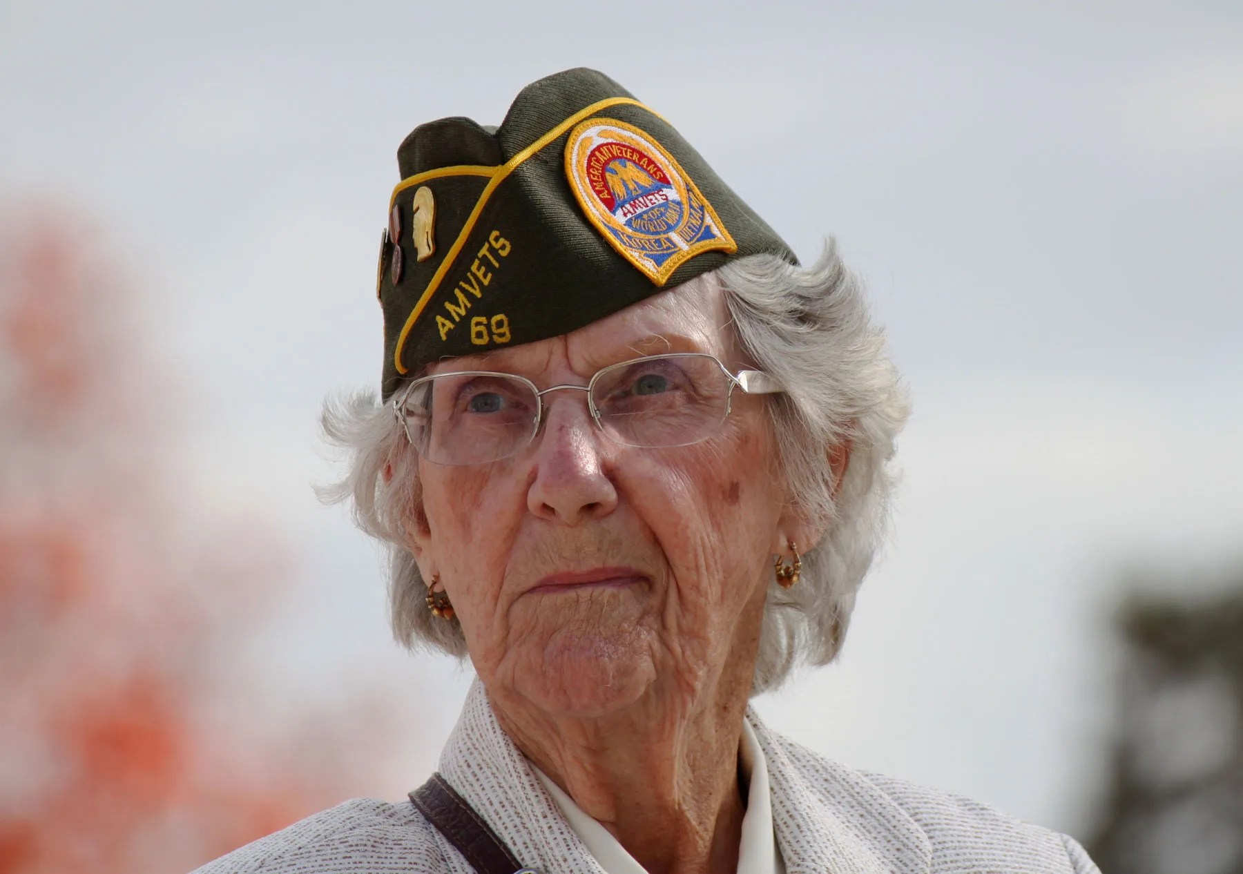 Female Vietnam veteran standing proud wearing a AMVETS military hat